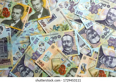 Multiple Romanian RON Banknotes Laying Flat On A White Surface 