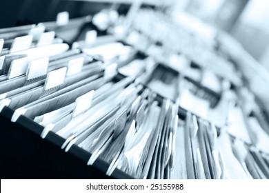 Multiple rows of filing cabinets in an office or medical establishment, overflowing with files.  Narrow depth of field to emphasize the "neverending" feeling