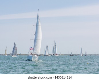 Multiple Sailboats Sailing On The Ocean On A Bright Sunny Day