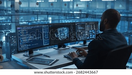 With Multiple Screens Open to Code and Analyze Neural Network Visualizations, African Software Developer in a Data Center Refines an AI Algorithm, Working Methodically to Improve the Product