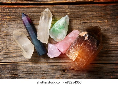 Multiple semi precious gemstones on wooden boardfluorite, quartz, smoky quartz, rose quartz. 