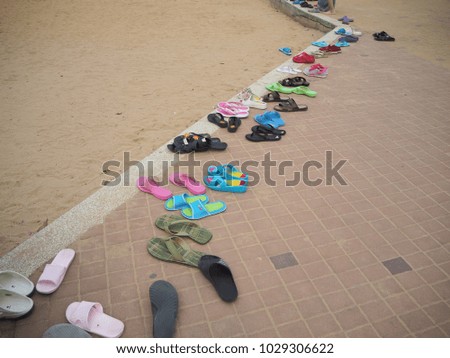 Multiple shoes on the beach.