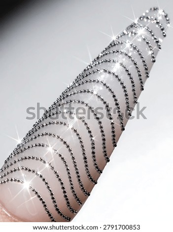 Multiple silver bracelets on a pink surface
