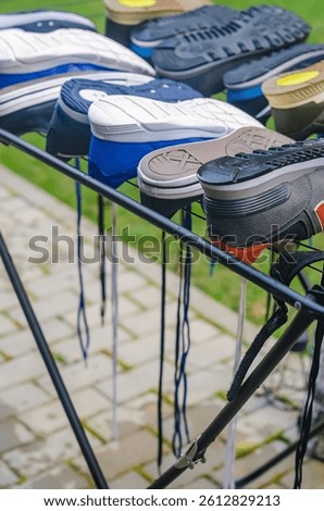 Multiple sneakers upside down on drying rack outdoors after cleaning and washing. High quality photo