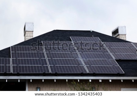 Multiple Solar Panels Installed On Roof Of Commerical Building With Overcast Sky And Anti-Bird Spikes