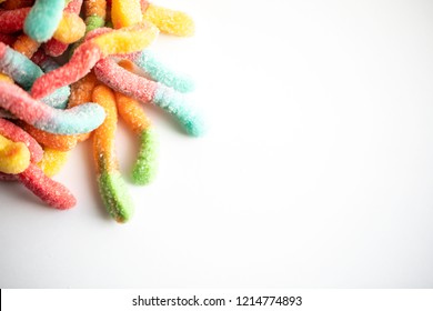 Multiple Sour Gummy Worms On A White Background