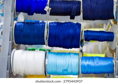 Multiple spools of deep navy and midnight blue ribbons, each radiating a soft sheen. Their elegant tones are perfect for refined crafts, decor, or formal gift presentations.