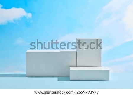 Multiple stacked white blocks with blue sky background, creating a minimalist platform for sunscreen, SPF skincare, or cosmetic product mockups.