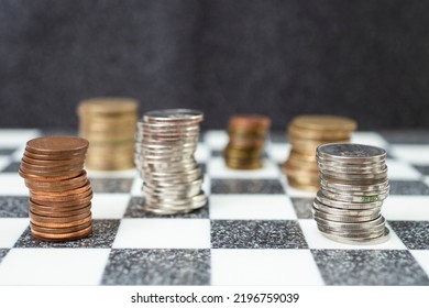 Multiple Stacks Of Coins On A Chess Board, Close Up Side View