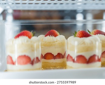 Multiple strawberry mini cakes lined in display fridge dessert bakery concept