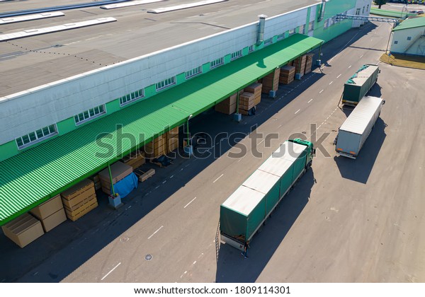 multiple trucks\
loading at the factory top\
view.