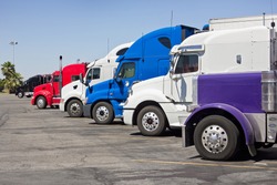 Multiple trucks park in a large parking lot., an Industrial Photo by Johnny Habell