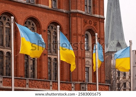 Multiple ukrainian flags waving in front of Rotes Rathaus builidng, Berlin city hall, representing support, political unity,  international solidarity and support for Ukraine