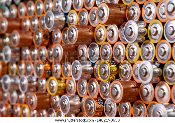 Multiple\
used AA alkaline batteries are seen arranged in a pile. Closeup\
side view from the plus side of the\
battery.