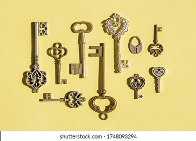 Multiple vintage keys isolated on a yellow background. Image of old antique keys,  top view, flat lay