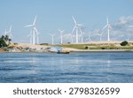 Multiple Wind Turbines Over Dunes with Anchored Boats and River in Northeast Brazil