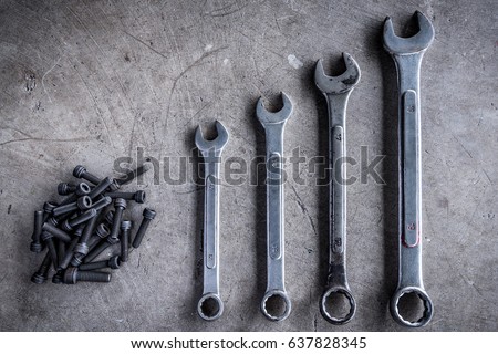 Multiple wrenches placed on the floor and screws.