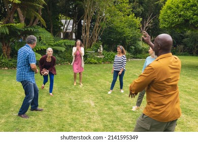 Multiracial active senior male and female friends playing rugby in backyard on weekend. unaltered, lifestyle, friendship, leisure, sport and active seniors. - Powered by Shutterstock