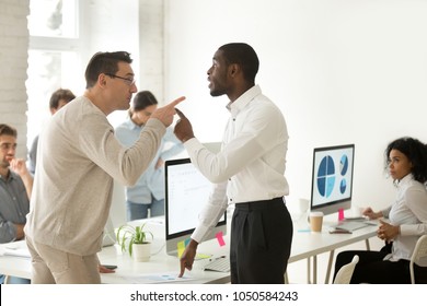 Multiracial african and caucasian colleagues disputing having disagreement at work blaming each other in mistake, diverse coworkers arguing about project, having conflict fight at workplace concept