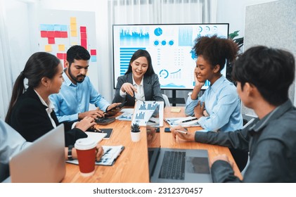 Multiracial analyst team use BI dashboard data to analyze financial report on meeting table. Group of diverse business people utilize data analysis by FIntech for business marketing decision. Concord - Powered by Shutterstock