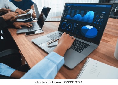 Multiracial analyst team use BI Fintech software to analyze financial data on meeting table. Financial dashboard data display on laptop screen with analyzed chart for marketing indication. Concord - Powered by Shutterstock