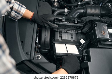 Multiracial auto repair shop employee works under hood of car - Powered by Shutterstock