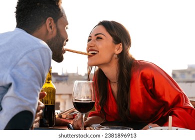 Multiracial beautiful happy couple of lovers dating on rooftop balcony,  Barcelona - Multiethnic people having romantic aperitif dinner on a terrace with city view, concepts about tourism and people  - Powered by Shutterstock