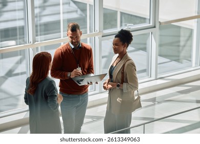 Multiracial busines team talking while working on laptop in the office. Copy space. 