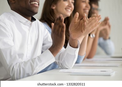 Multiracial business audience people group smiling applauding sitting at conference table clapping hands at corporate training seminar meeting, appreciation applause ovation concept, close up view