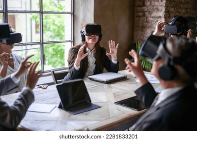 Multiracial business people hi-tech meeting, creative teamwork standing in modern office and using vr headsets, trying new project and gesturing in the air - Powered by Shutterstock