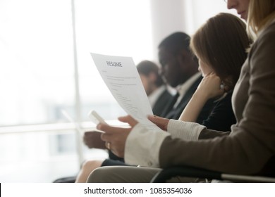 Multiracial Business People Waiting In Queue Preparing For Job Interview Concept, Diverse Unemployed Vacancy Applicants Holding Reading Cvs Getting Ready, Human Resources Concept, Focus On Resume