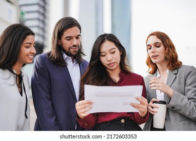 Multiracial Business People Working Outside Of Office With Tower In The Background