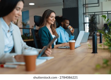 Multiracial colleagues collaborating and using technology in a contemporary coworking space