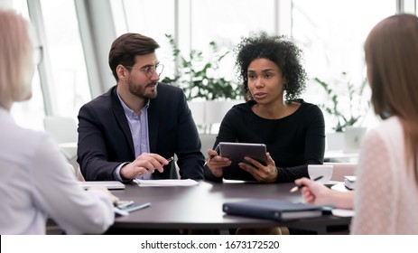 Multiracial colleagues coworkers brainstorm discuss company business project together, concentrated multiethnic businesspeople work in group, cooperate consider corporate startup strategy at meeting - Shutterstock ID 1673172520