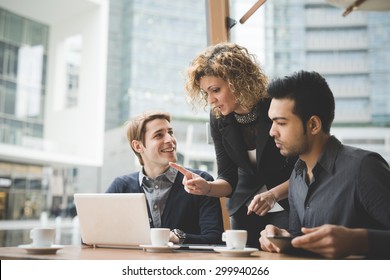 Multiracial contemporary business people working connected with technological devices like tablet and laptop, talking together - finance, business, technology concept