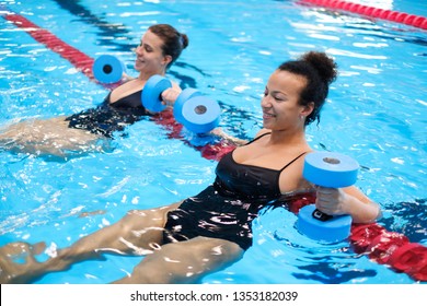 Multiracial couple attending water aerobics class in a swimming pool