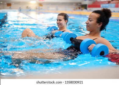 Multiracial couple attending water aerobics class in a swimming pool - Powered by Shutterstock