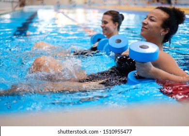 Multiracial couple attending water aerobics class in a swimming pool - Powered by Shutterstock