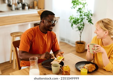 Multiracial couple enjoying breakfast together at home - Powered by Shutterstock