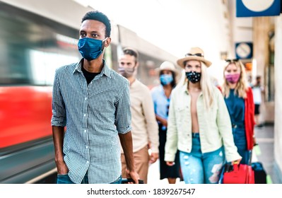 Multiracial Crowd Of People Walking At Railway Station Platform - New Normal Travel Concept With Young Travelers Covered By Protective Face Mask - Focus On African American Guy At Left