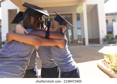 Multiracial elementary schoolboys wearing mortarboard while making huddle against school building. unaltered, imitation, education, together, school and graduation concept. - Powered by Shutterstock