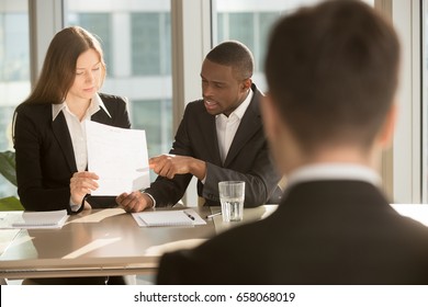 Multiracial employers or recruiters making hiring decision, discussing resume while job applicant waiting for result, employee selection team considering candidate cv before after personal interview