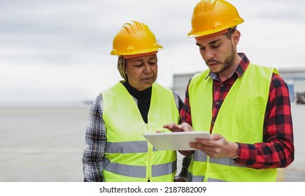 Multiracial Engineer Workers Working At Construction Site Using Tablet Computer - Focus On Latin American Senior Woman