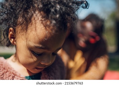 Multiracial Family Concept. Black Father And White Mother Playing With Their Daughter In The Park And Spending The Day Together. Focus On A Baby Girl.