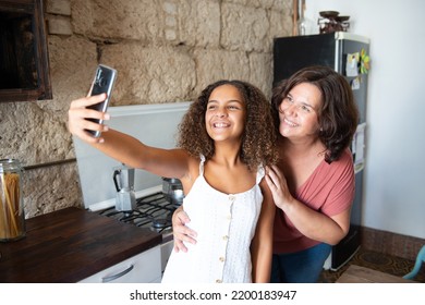 Multiracial family taking a selfie in the kitchen of their home - Shutterstock ID 2200183947