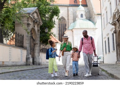 Multiracial Family Travel Together With Suitcases, Walking In Old City Centre.