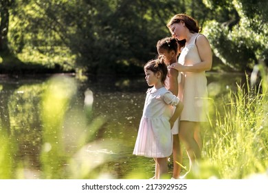 A Multiracial Family Watching Birds On A Pond On A Summer Day In The Park,side View.Summer,diversity Concept.Selective Focus,copy Space.