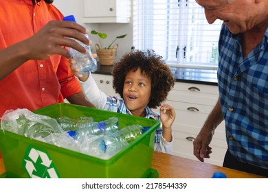 Multiracial father and grandfather teaching boy to recycle waste by throwing plastic bottles in bin. Multigeneration, unaltered, together, childhood, unaltered, environmental conservation, garbage. - Powered by Shutterstock