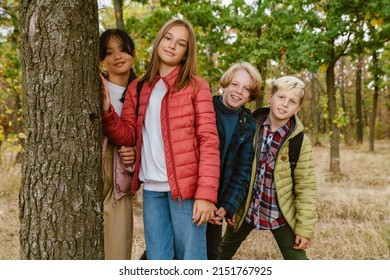 Multiracial Four Teenagers Smiling During Hiking In Autumn Forest