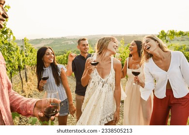 Multiracial friends dancing at summer party inside vineyards - Happy people having fun together drinking red wine  at coutryside resort - Travel, celebration and tasting event concept - Focus on faces